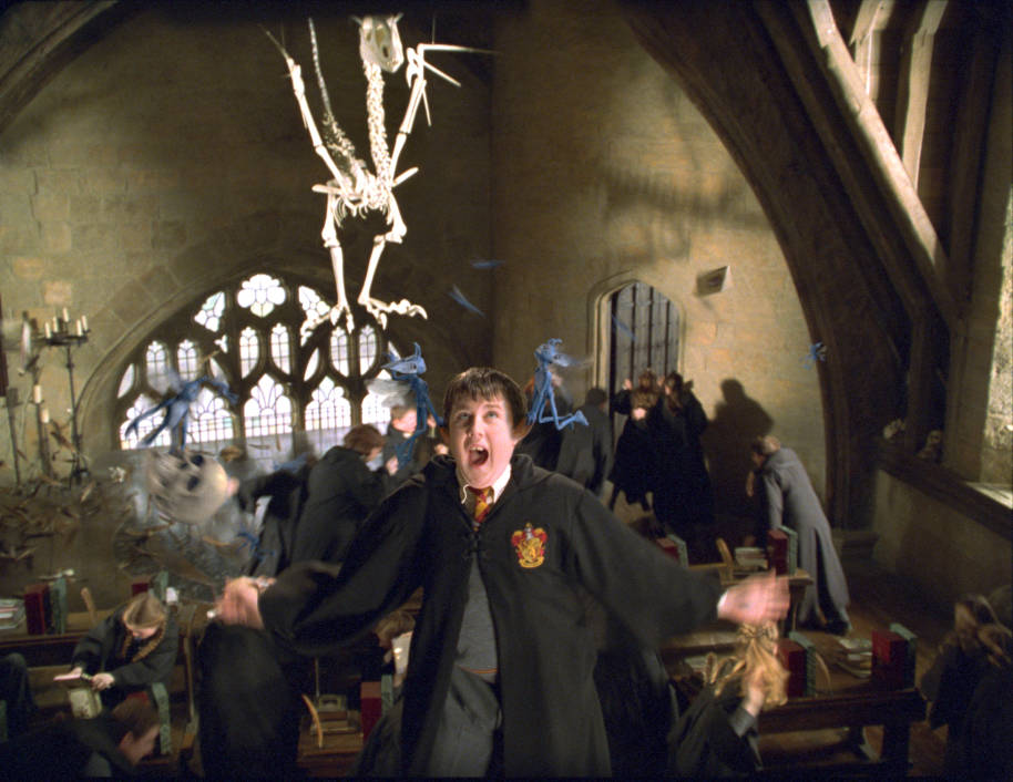 Neville is suspended by the ears by two Cornish pixies, during Defence Against the Dark Arts