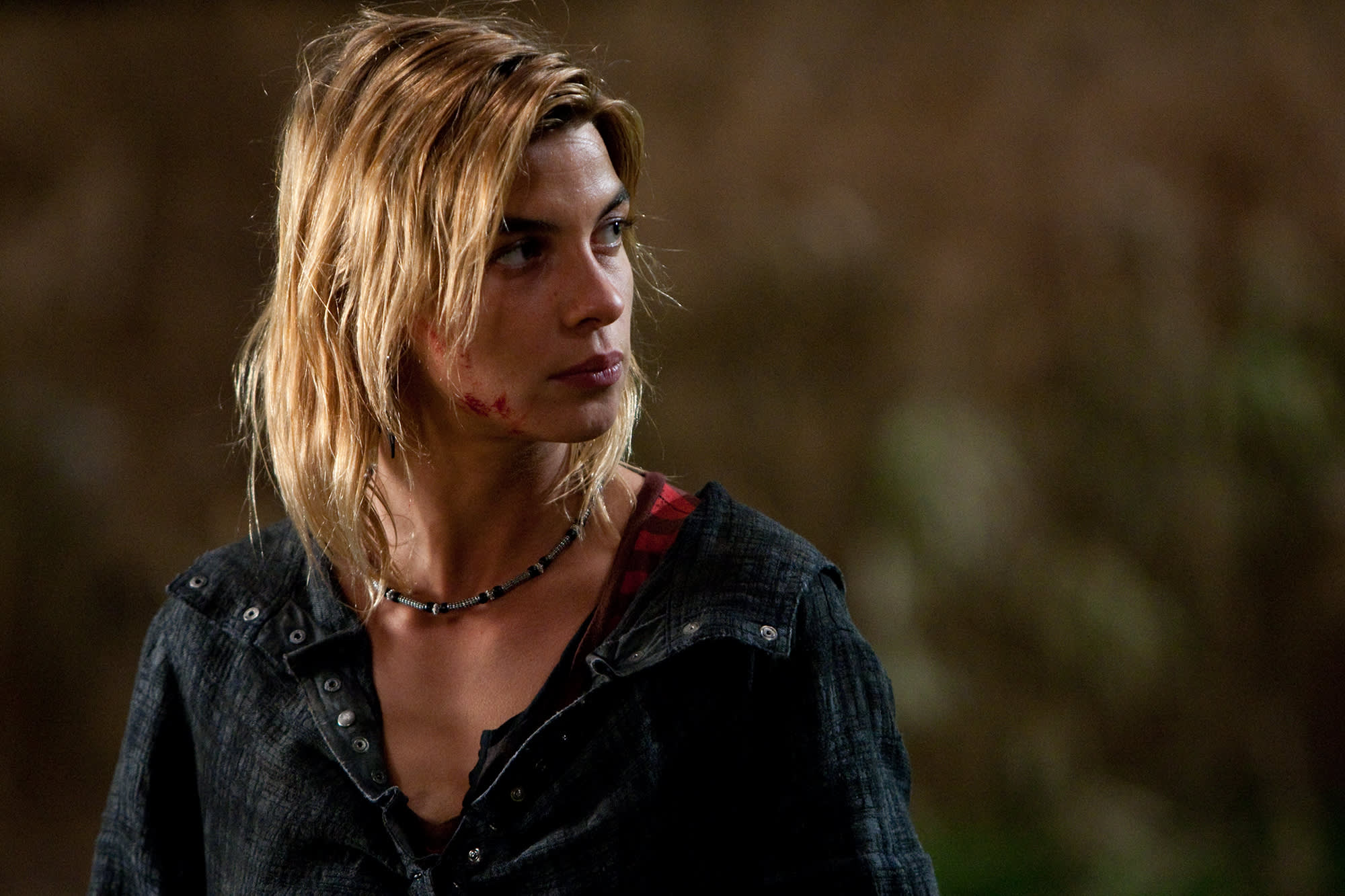 A close-up of Tonks standing outside with blood on her face while looking to her left