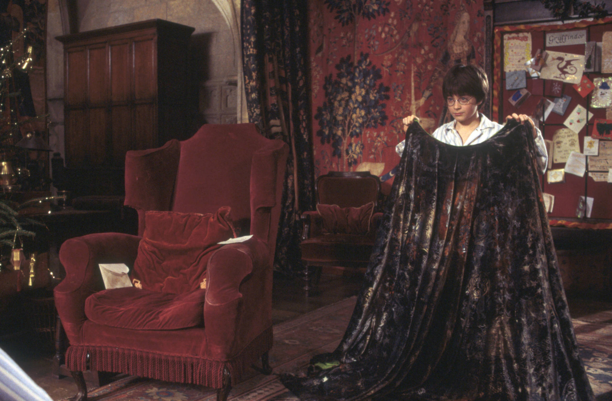 Harry holding the invisibility cloak