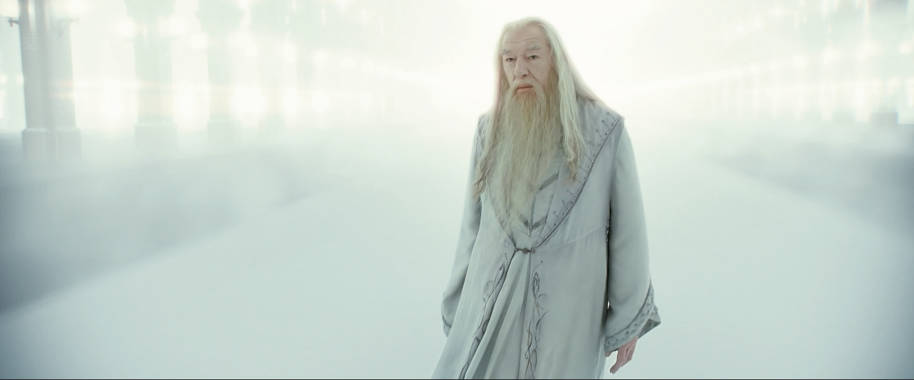 Albus Dumbledore stands in a dream version of King's Cross station which is empty, hazy and white.