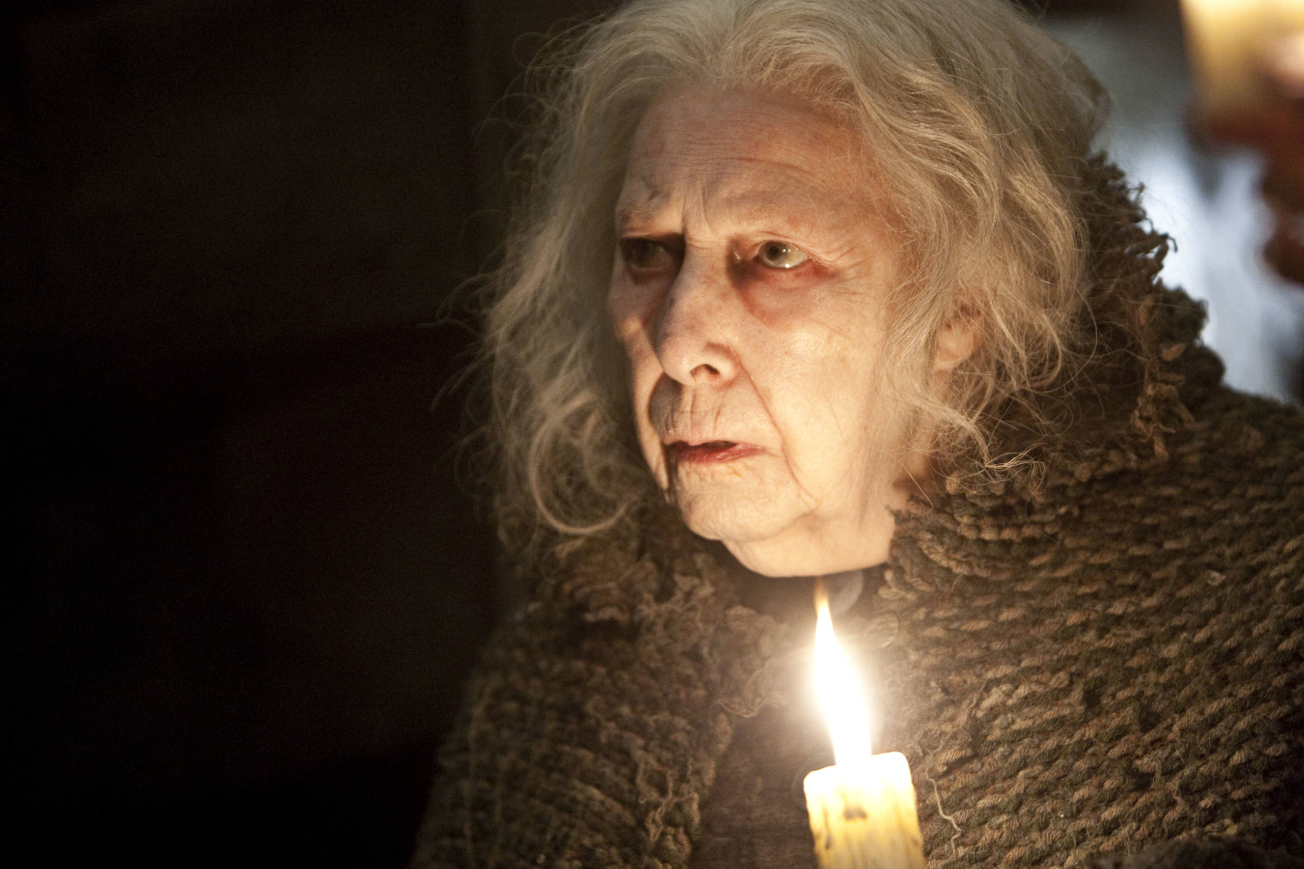 Close-up film still of Bathilda Bagshot holding candle