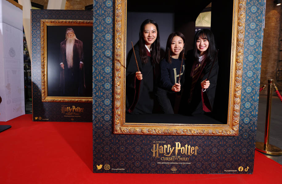 Fans pose for their Hogwarts portrait with Albus Dumbledore in the background!