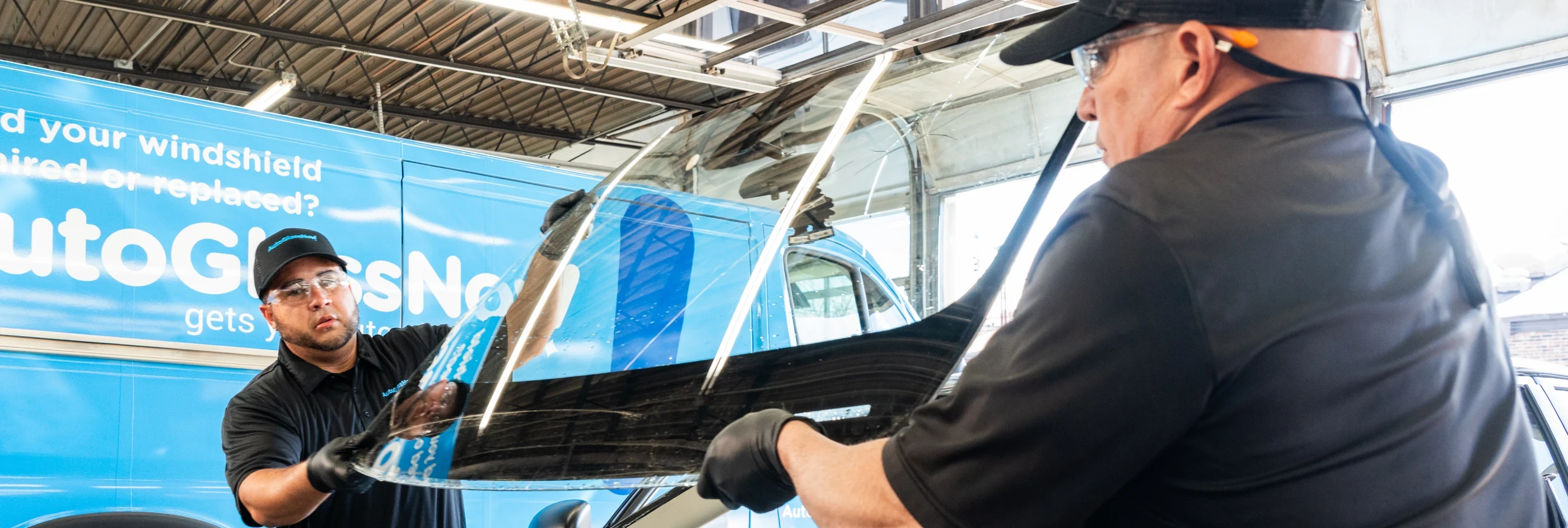 Technician repairing a chip in a windshield