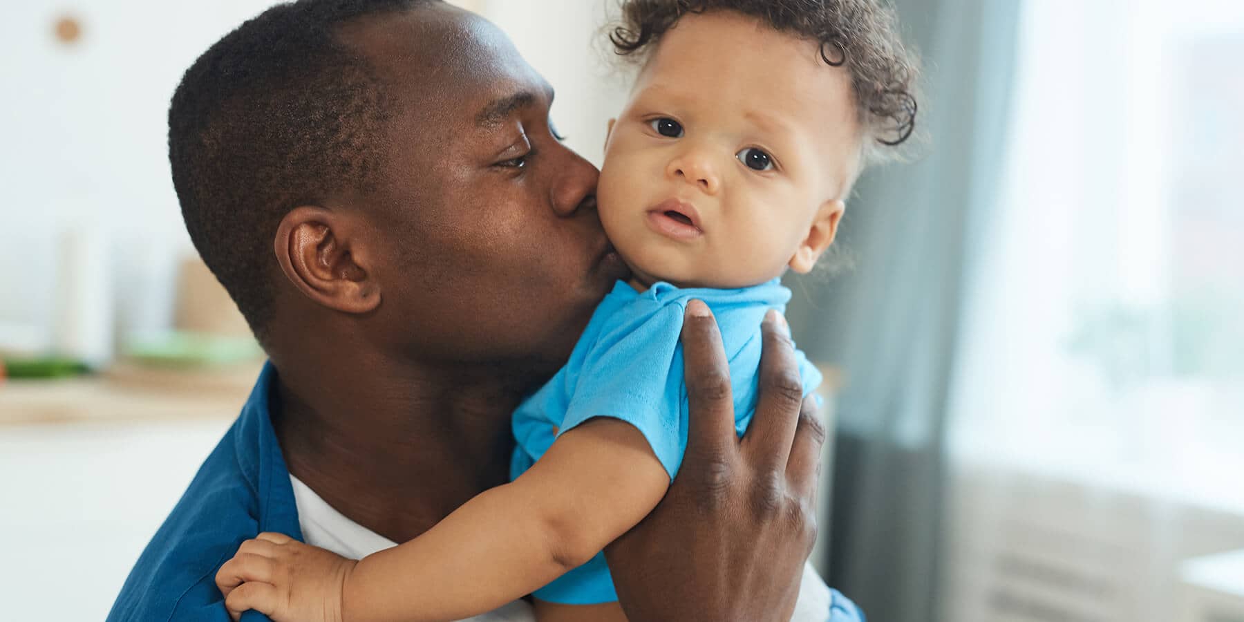 Father holding and kissing his baby