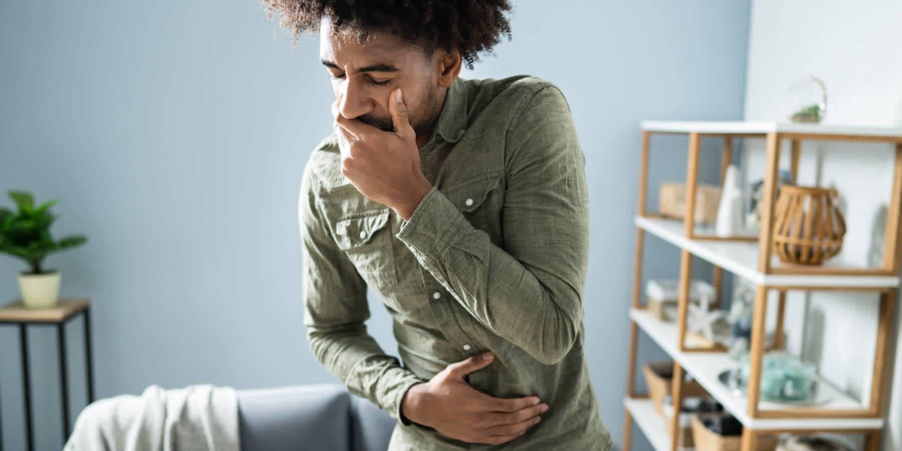 Man experiencing uncomfortable symptoms and wondering about the difference between indigestion vs. heartburn