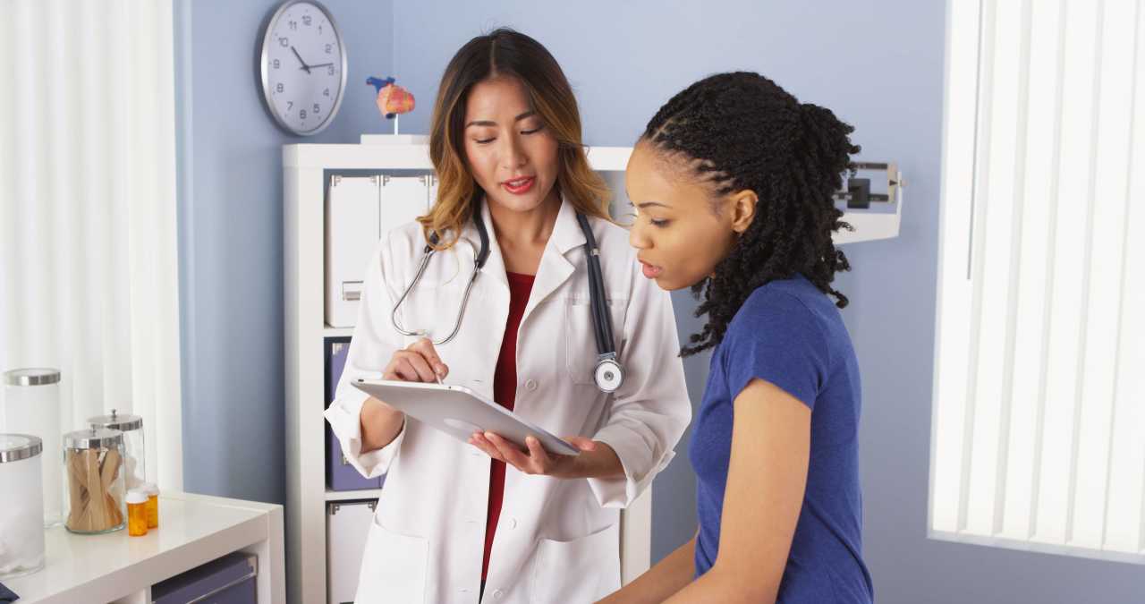 Healthcare provider in office explaining what AMH is to female patient