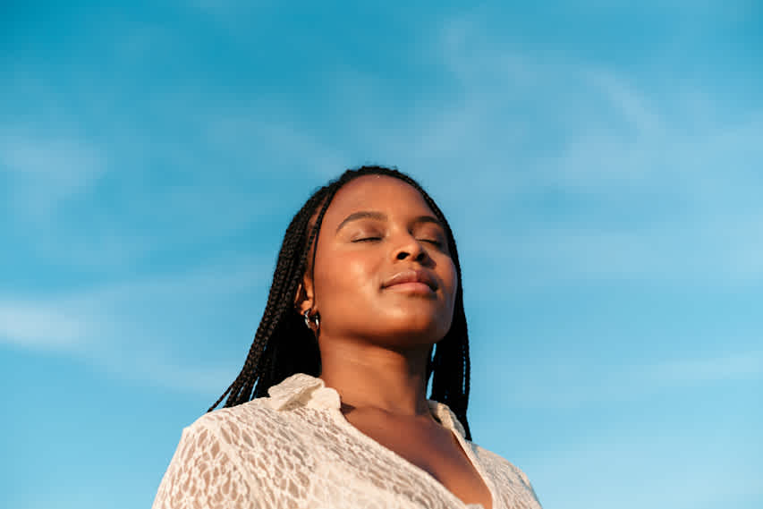 woman with closed eyes and sky in the background