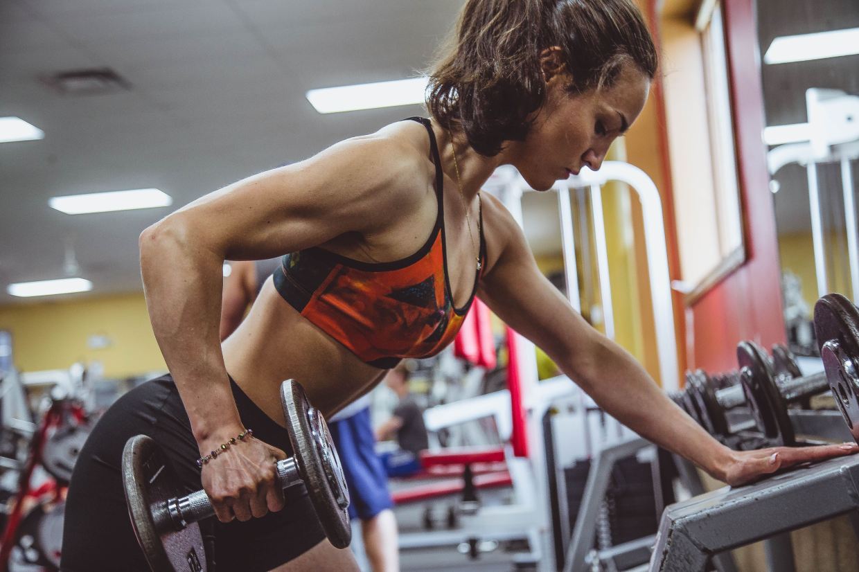 Woman athlete training in the gym with improved performance due to hormone tracker