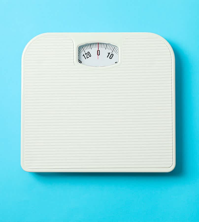 Bathroom scale for weight management against a sky blue background