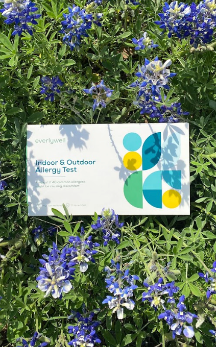 Everlywell indoor and outdoor allergy test outside against purple flowers. 
