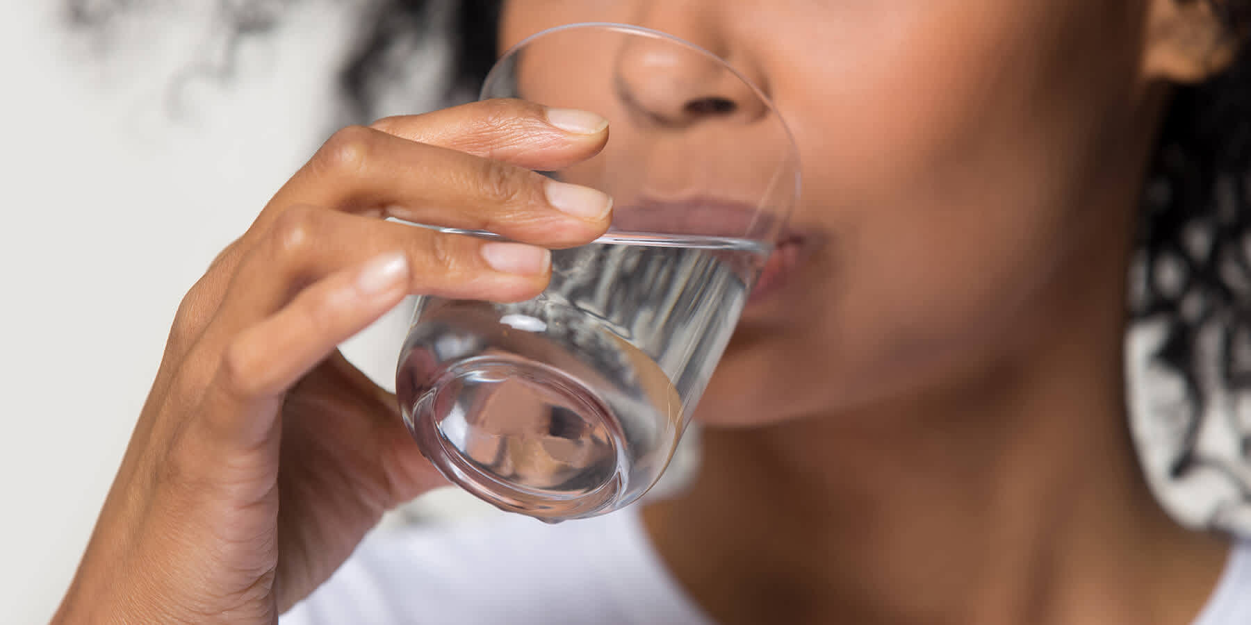 Woman drinking a glass of water after a meal to help digestion