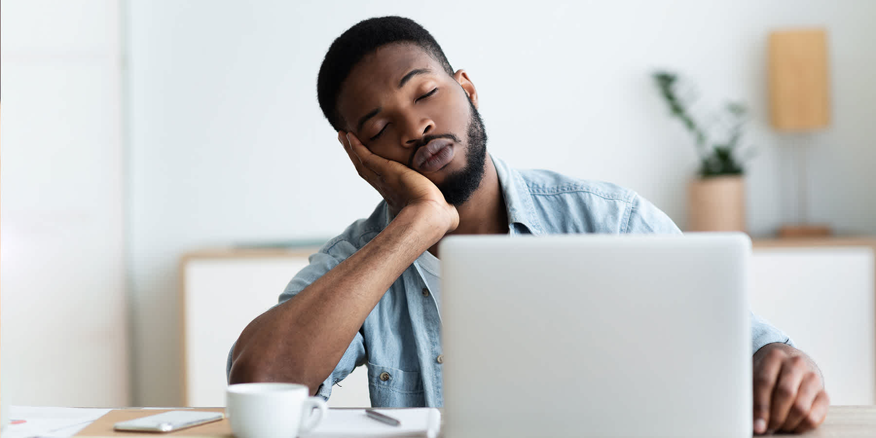 Tired man with sleep apnea falling asleep at desk