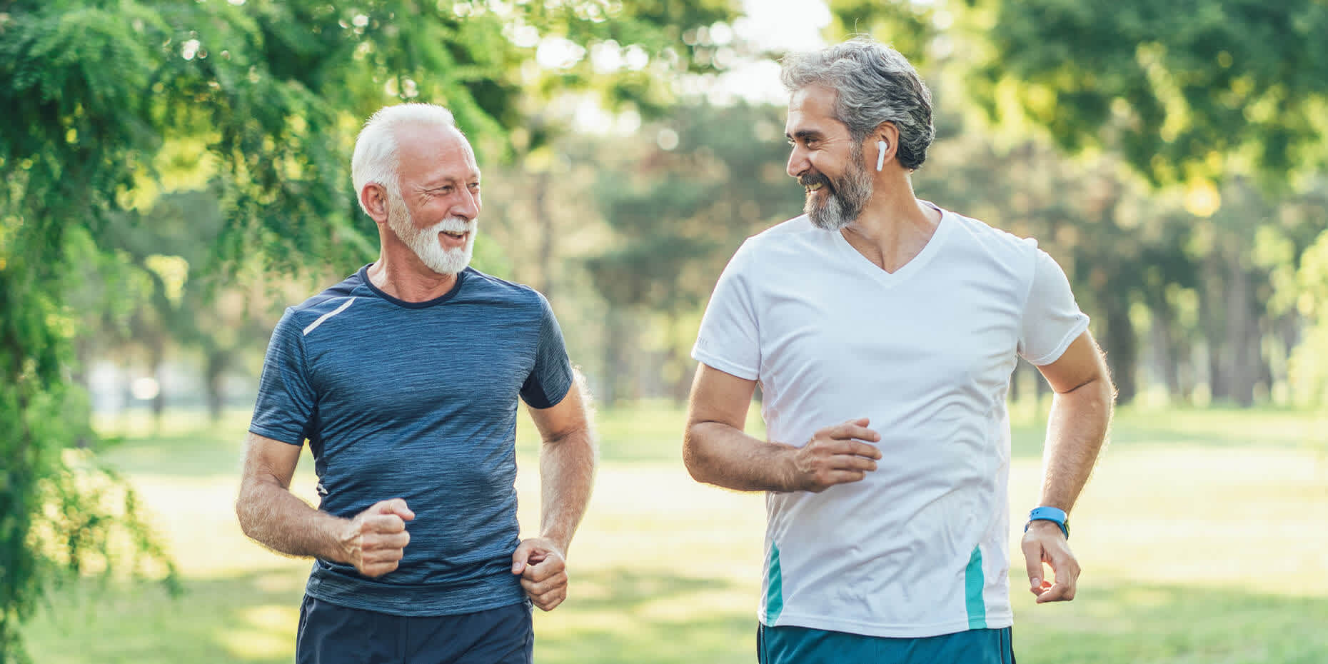 Two men smiling while jogging and discussing the effect of exercise on blood sugar