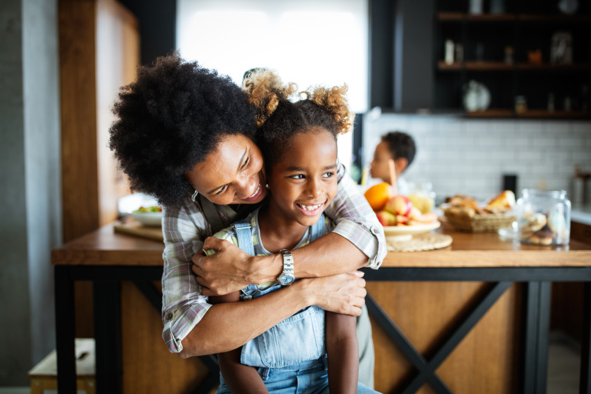 mother and child hugging in kitchen