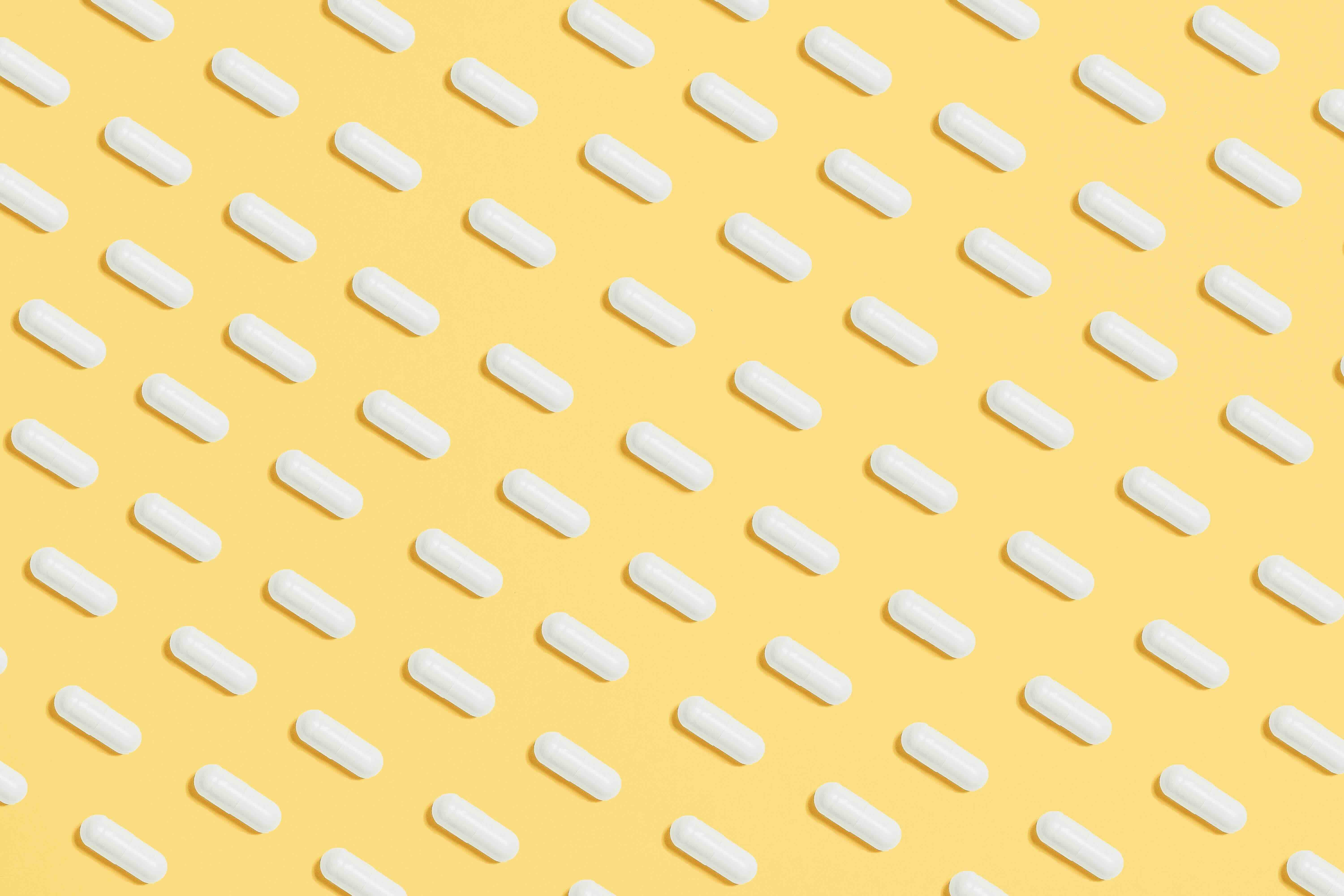 Antibiotic capsules against a yellow background