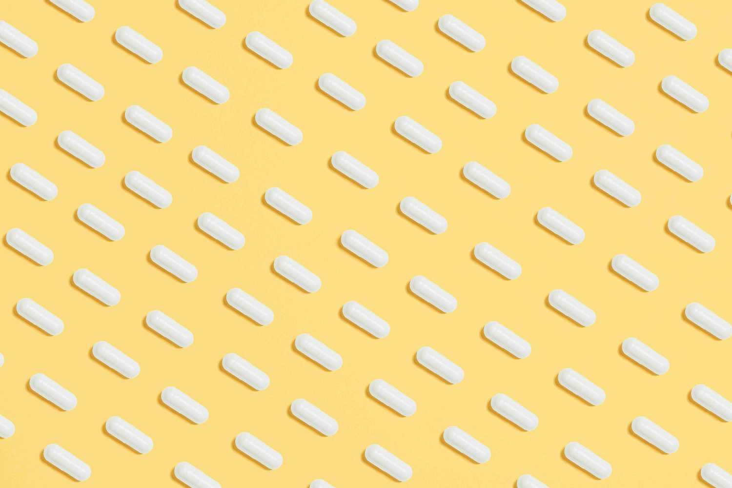 Antibiotic capsules against a yellow background