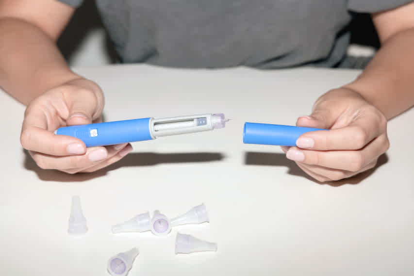 hands holding semaglutide pen