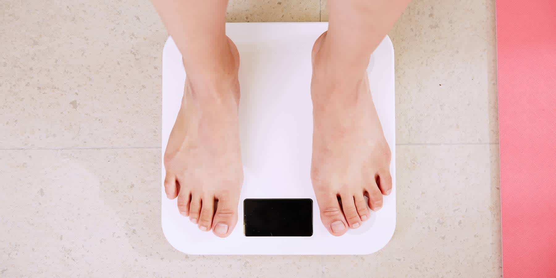 Person checking weight on scale after bariatric surgery and weight loss drugs