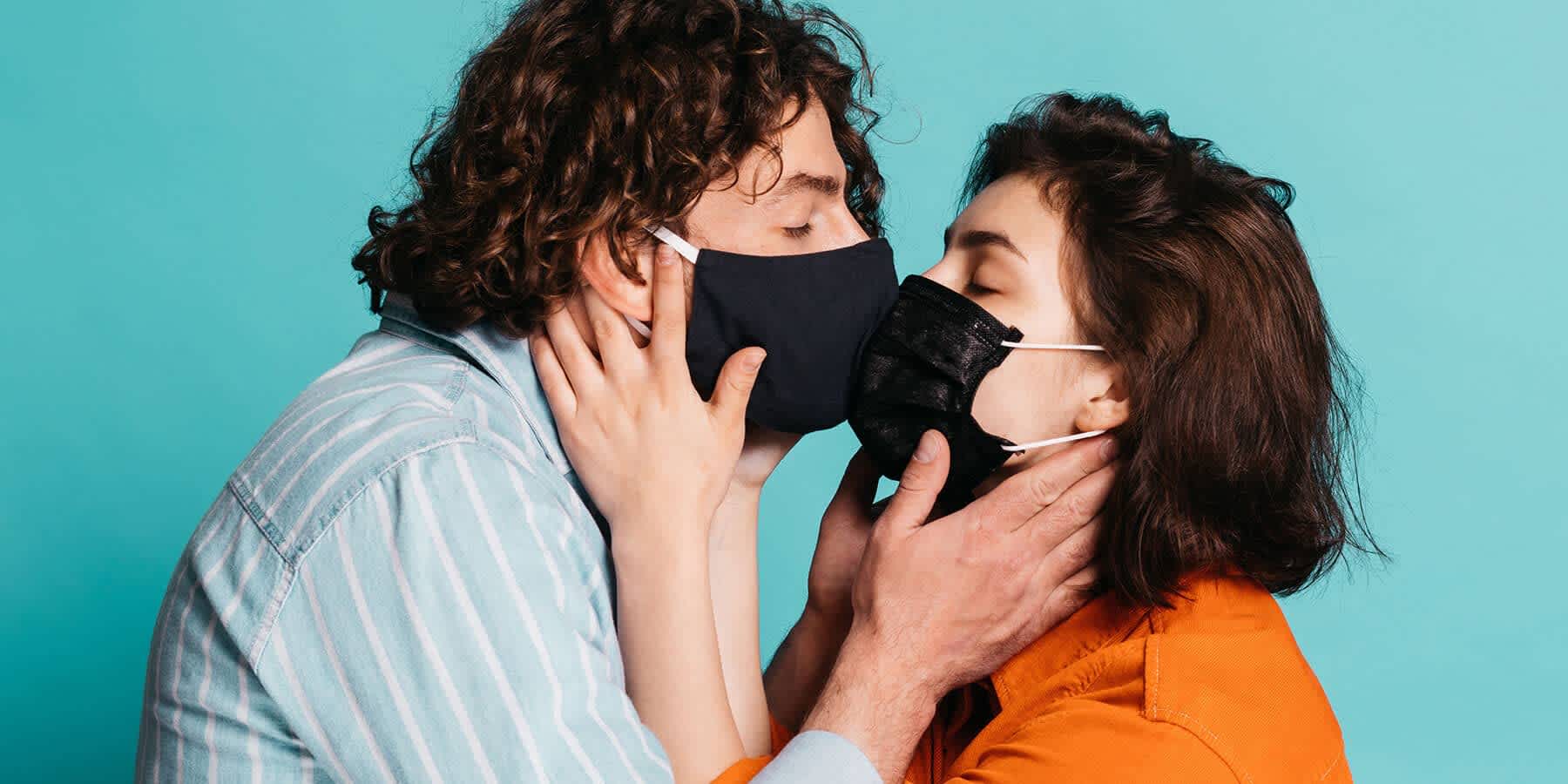 Couple wearing masks kissing during COVID-19 pandemic