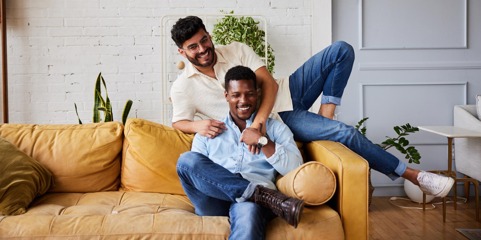Smiling couple on couch after learning what Descovy® is used for