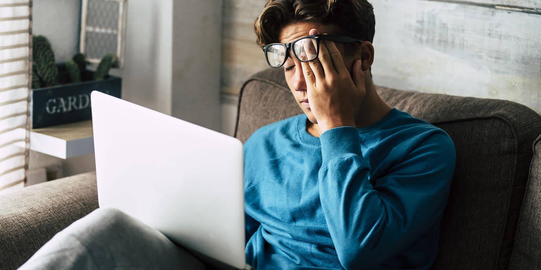 Young man with laptop feeling stressed out with high cortisol levels