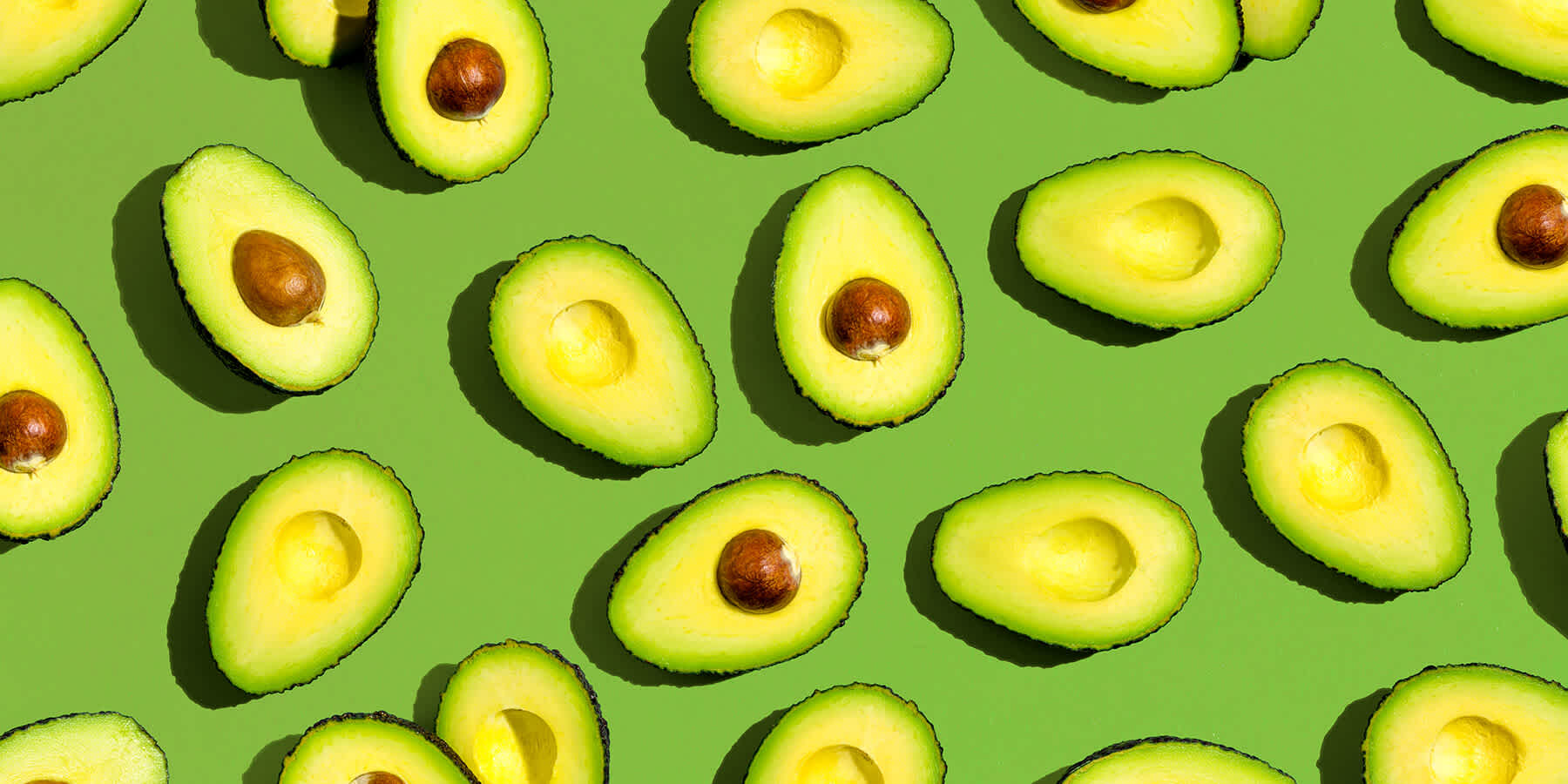 Green background with multiple halved avocados that may be good for weight loss