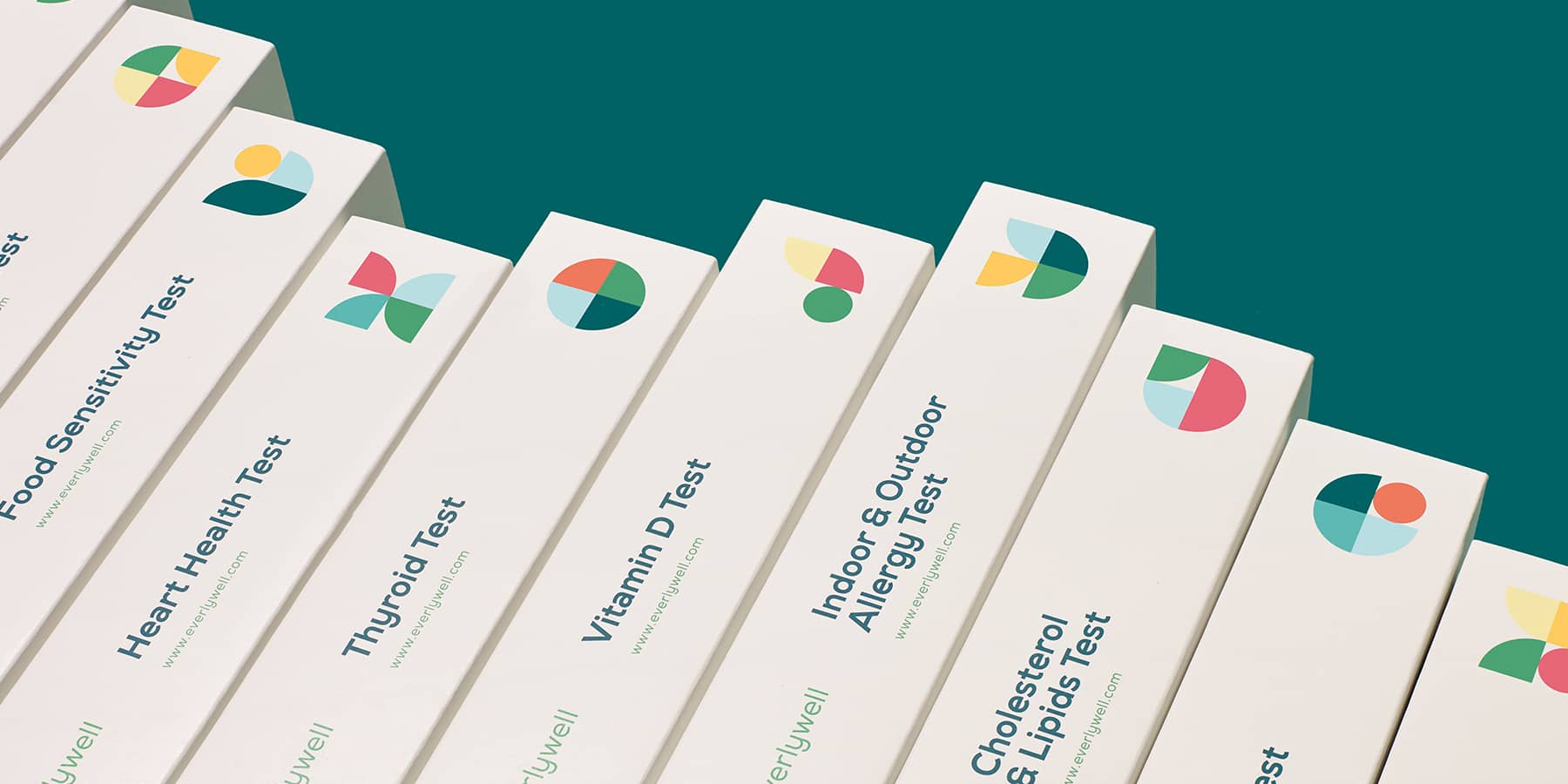 Row of lab test kits to support preventive healthcare against a teal background