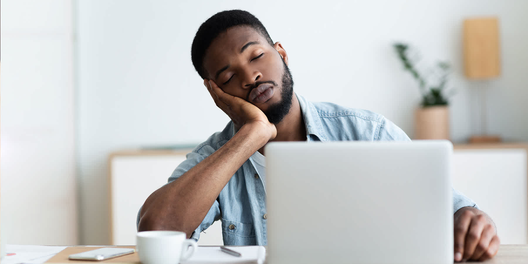 Man experiencing fatigue from iron deficiency falling asleep at desk