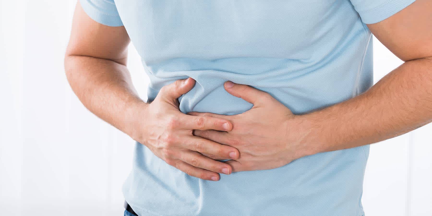 Man experiencing abdominal discomfort as a symptom of colon cancer in men