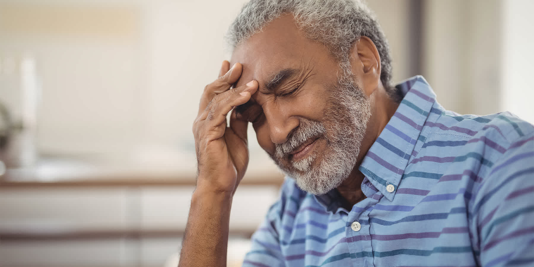 Elderly man with hand on his forehead wondering if arthritis is hereditary