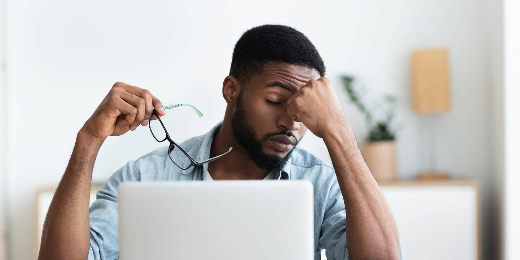 Man at desk experiencing fatigue as a vitamin D deficiency symptom
