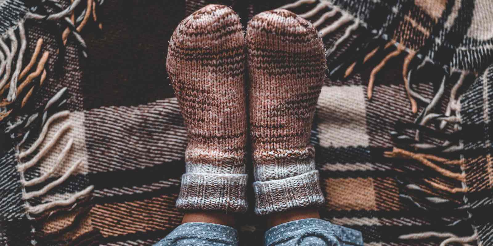 Person wearing thick, warm socks to alleviate cold sensitivity