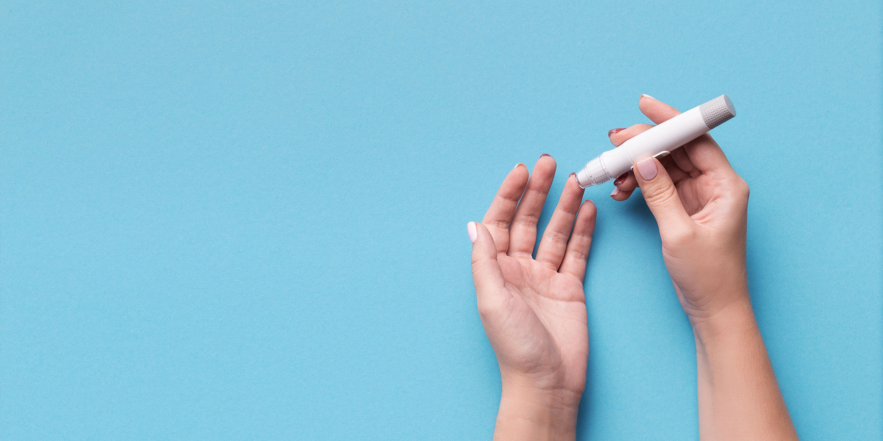 Person taking blood sample with finger stick for blood sugar glucose monitoring