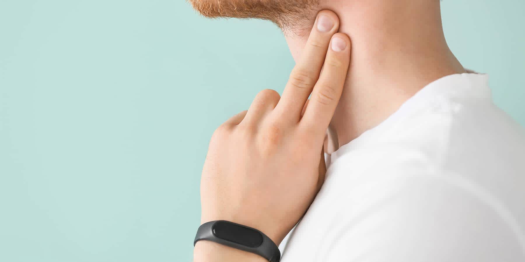 Man putting fingers on neck to check signs of heart disease