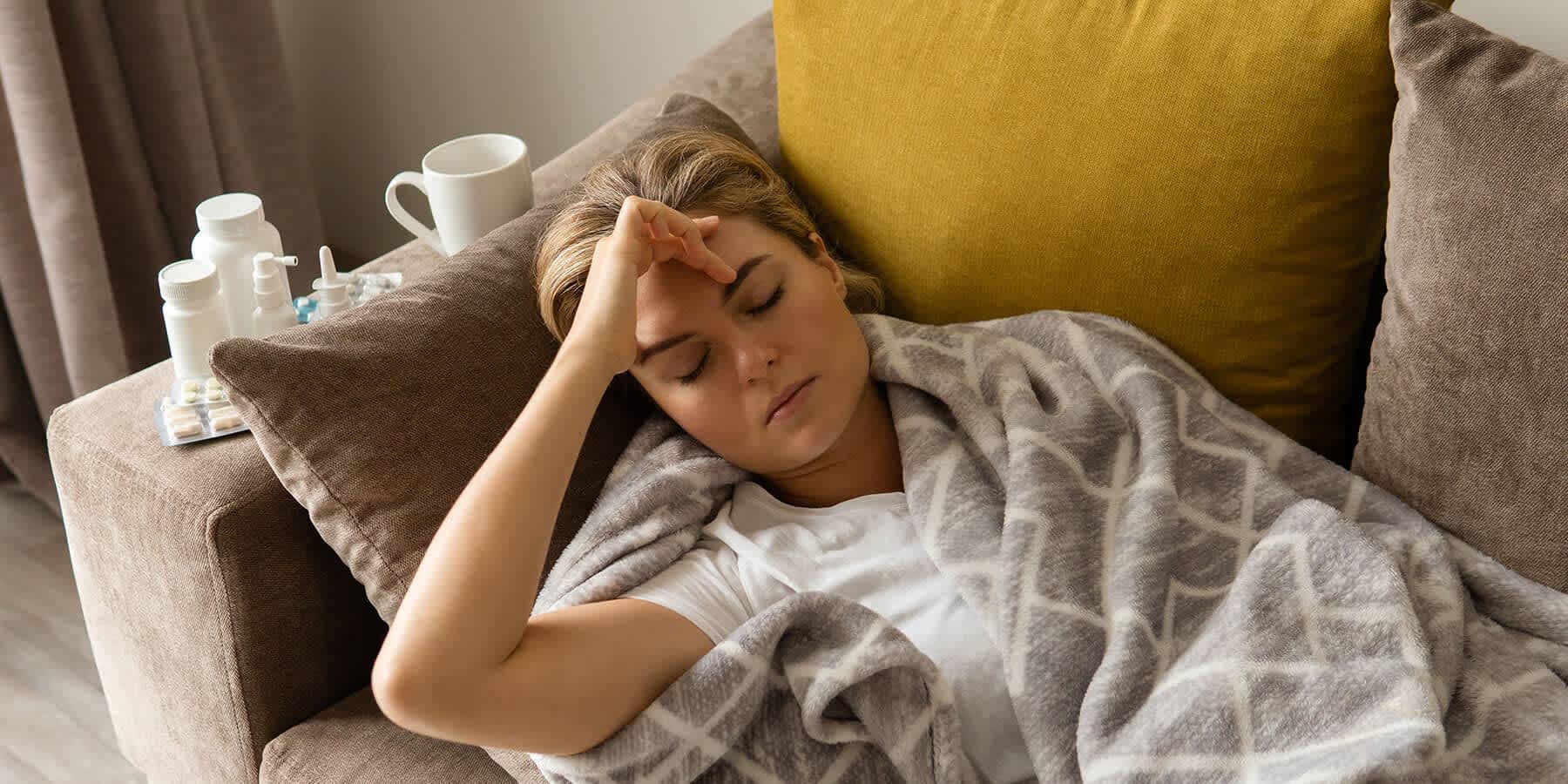 Woman lying on couch with migraine