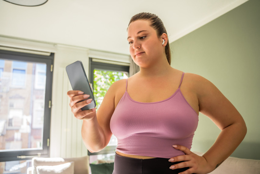 Woman with airpods in looking at phone