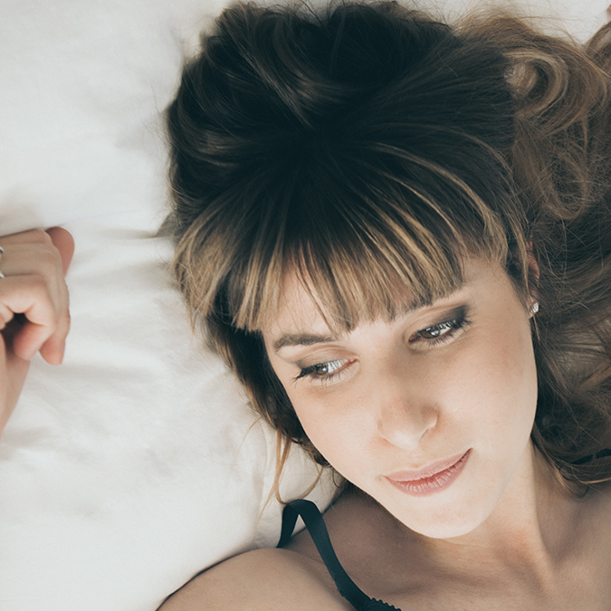 Woman lying in bed thinking about ovarian reserve