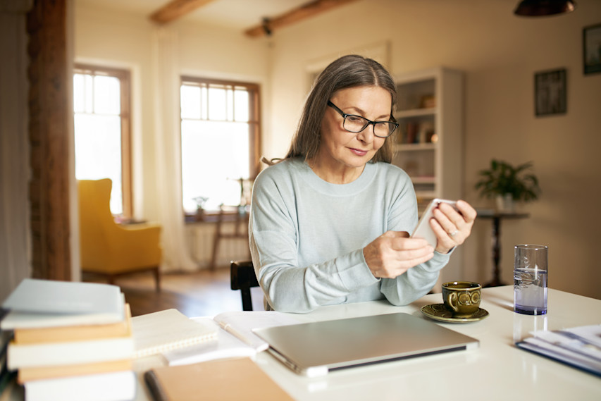 woman on phone at kitchen table