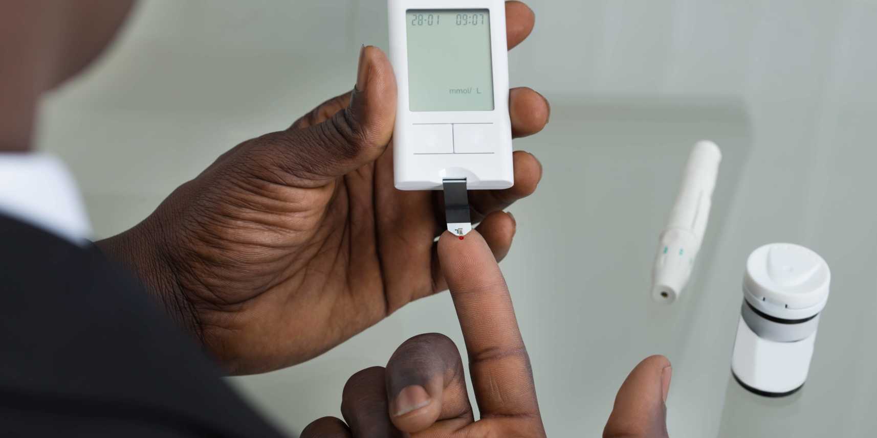 Person with obesity and diabetes checking blood sugar levels with glucometer