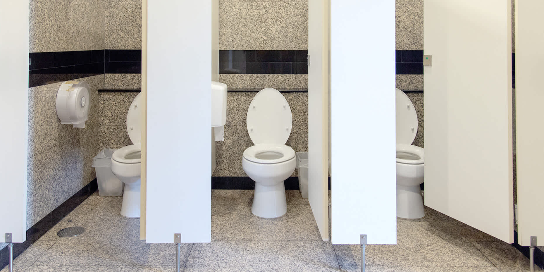 Bathroom stalls with toilets to represent frequent urination