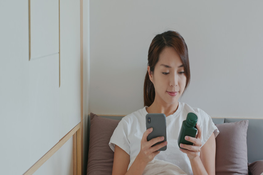 Woman sitting down and looking something up on phone
