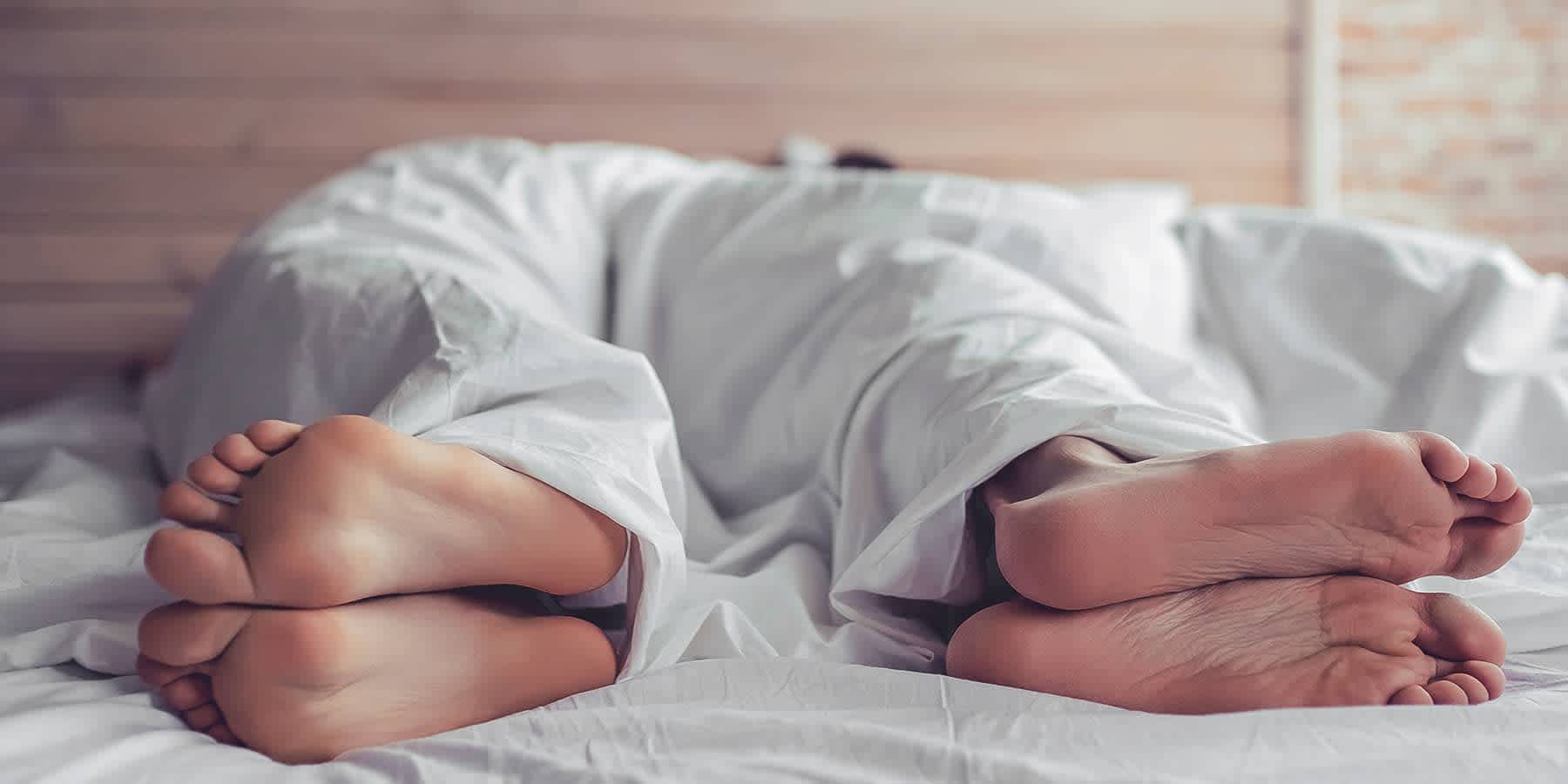 Couple lying in bed while facing away from each other wondering how to boost libido and sex drive