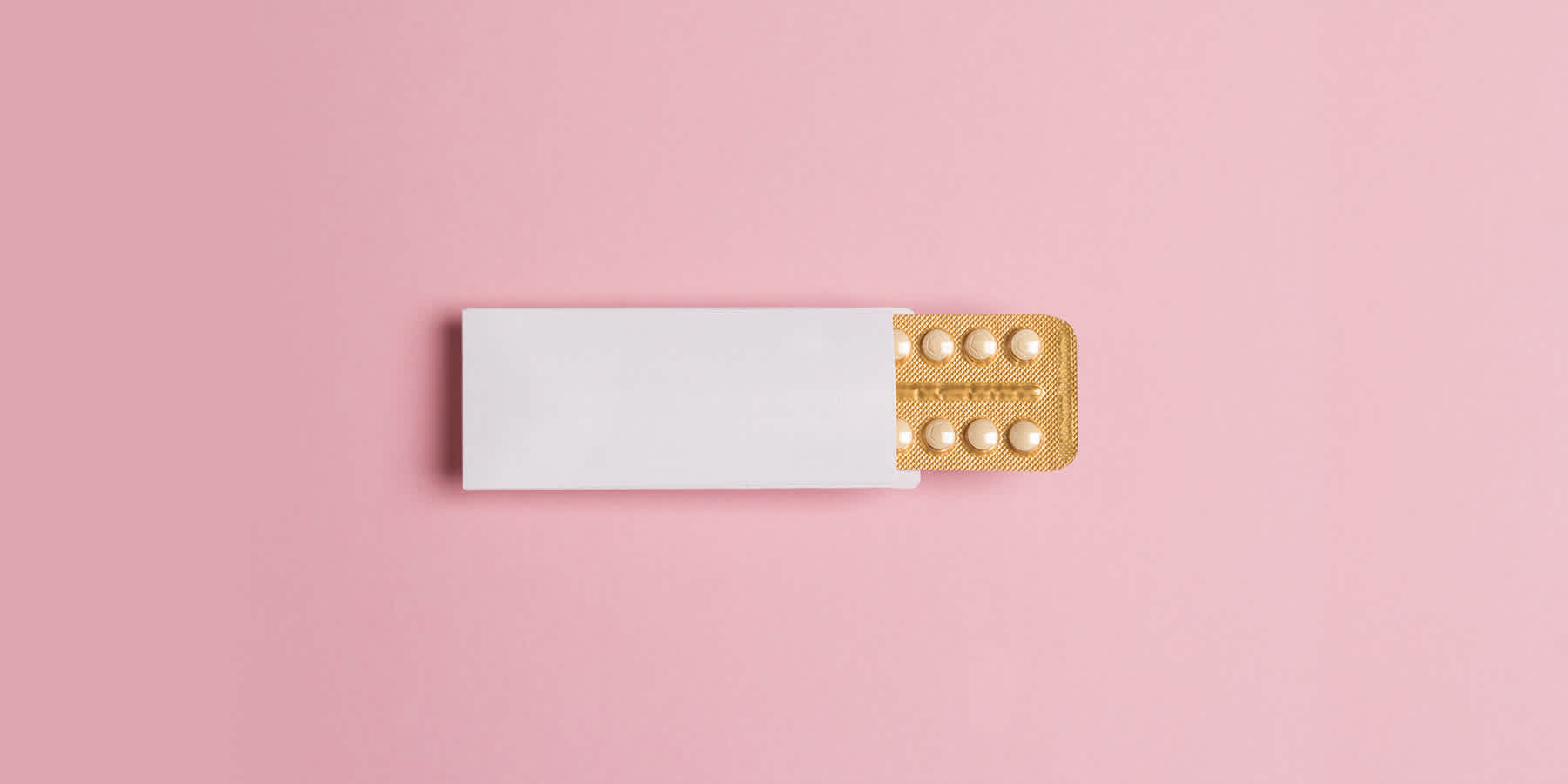 Packet of estrogen medication against pink background