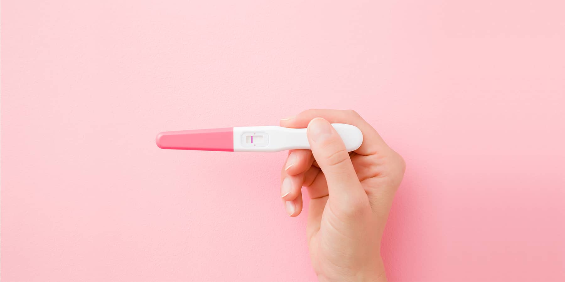Woman holding pregnancy test while wondering what luteal phase is
