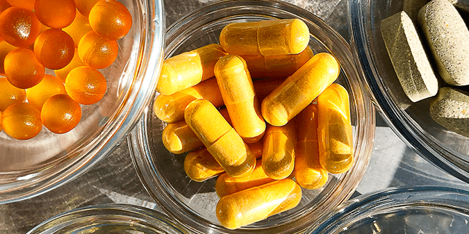 Glass container with capsules of B vitamin supplements that can help address vitamin B deficiency