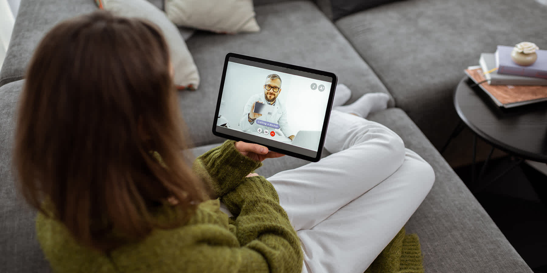 Woman experiencing synchronous telehealth by talking with provider via video on tablet