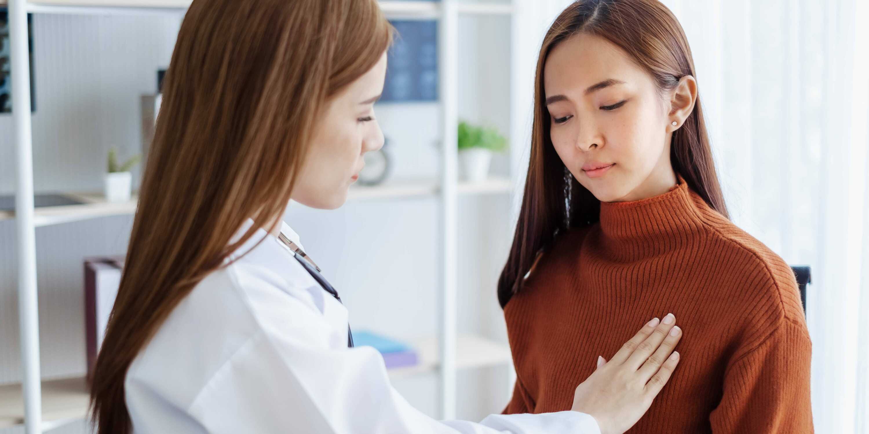 Physician examining woman for breast cancer