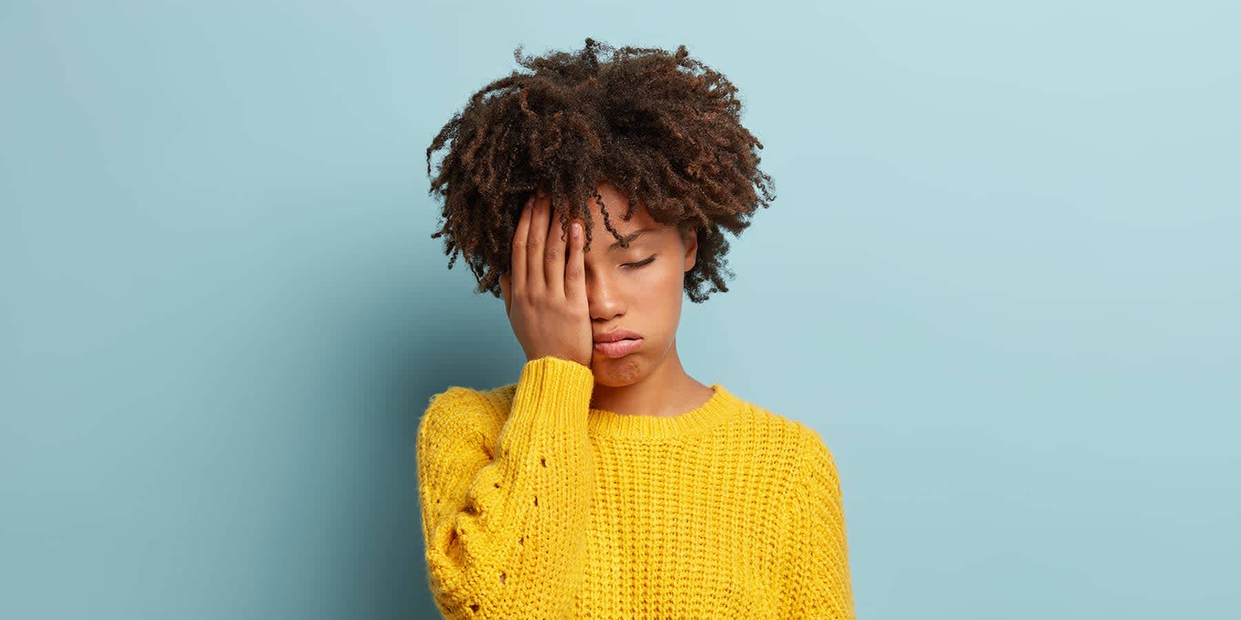 Distressed young woman in yellow sweater wondering about the causes of mood swings in females