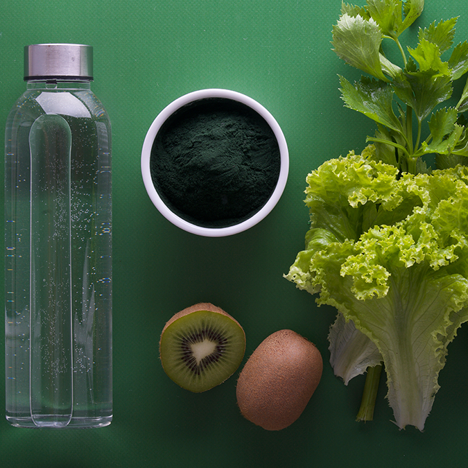 Water, fruits, and vegetables that aid in metabolism against green background