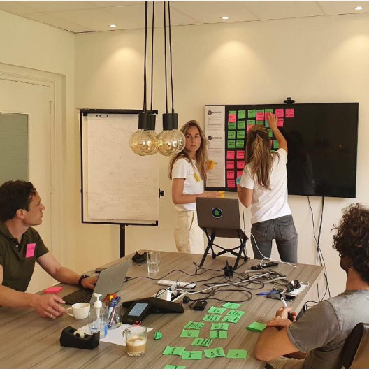 Fourthline members hanging sticky notes in meeting room